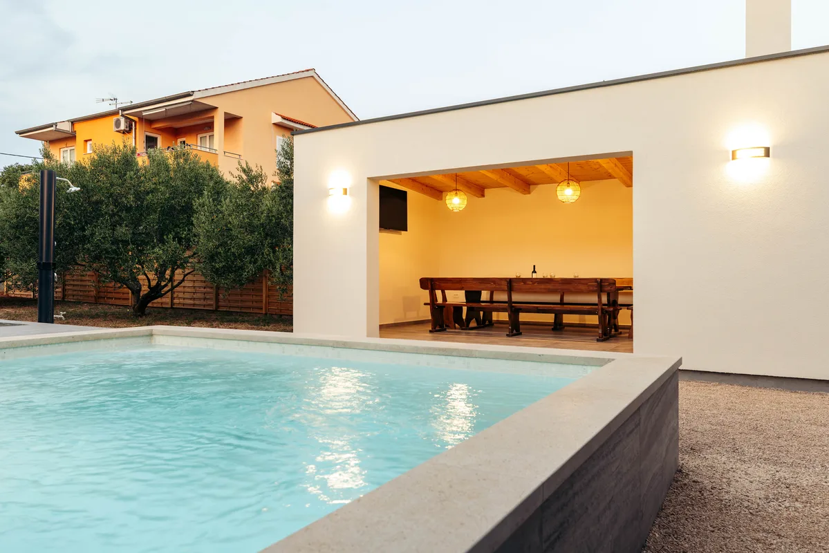 Swimming pool and garden house at dusk